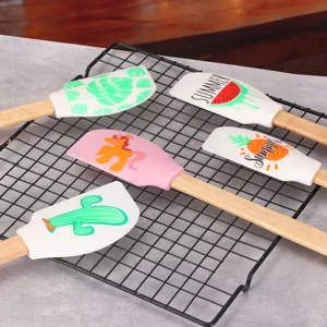 Silicone baking spatulas with wooden handles, cute prints, ideal kitchen tools for cake mixing.