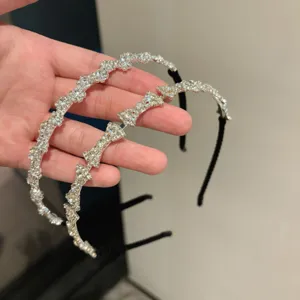 Vue détaillée de serre-têtes élégants en strass brillants avec des motifs de nœuds et vagues.