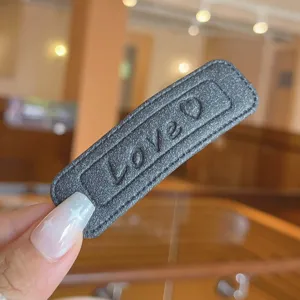 Stylish textured leather square hair clip with cute love embossed detail for daily wear.