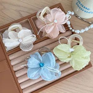 Chiffon flower hair claw detail showing delicate pearl chain and crystal heart embellishments.