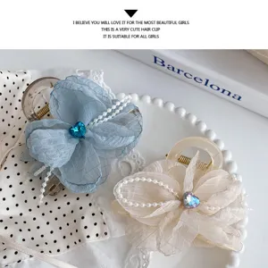 Close up of cute floral hair claws with pearl string and crystal heart details for daily wear.