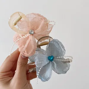 Detail view of elegant organza flower hair claw with pearl beads and crystal heart rhinestone.
