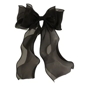 Close-up of a large black organza hair bow clip with long ribbons, elegant women hair accessory.