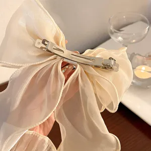 Large white organza bow hair clip, sheer ribbon barrette detail for elegant hairstyles.