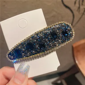 Detailed view of the sparkling blue crystal rhinestone hair clip with elegant silver metal trim.