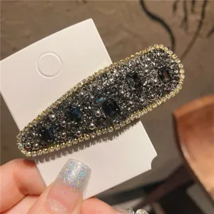 Detailed shot of sparkling rhinestone crystal hair clip in black and grey elegant design.