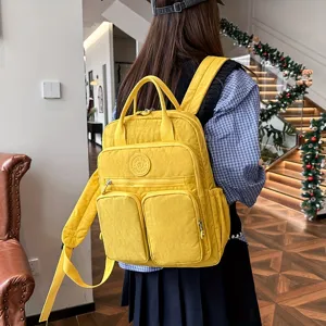 Detailed view of yellow multi-pocket nylon casual travel backpack with comfortable shoulder straps.