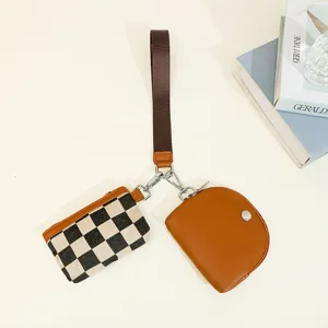 Two-in-one women wrist bag detail, featuring a retro checkered pouch and solid brown purse.