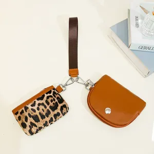 Detailed view of fashionable two-in-one women wrist bag, leopard print and brown coin purse.