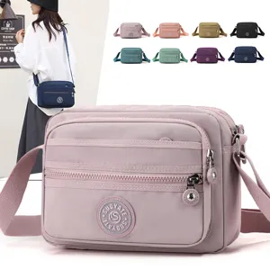 Nylon crossbody bag for women, multi-pocket casual shoulder bag with wide strap design.
