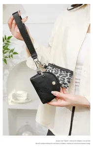 Close-up detail of a fashion 2-in-1 women wrist bag, leopard print and black leatherette.