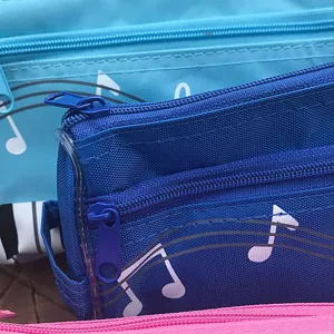 Estuche de lona doble con patrón de notas musicales, vista detallada con cremalleras.