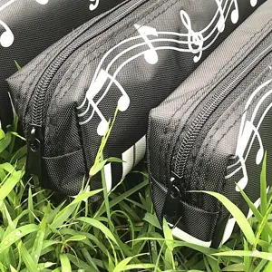 Gedetailleerd close-up van het zwarte etui met witte muzikale noten patroon erop.