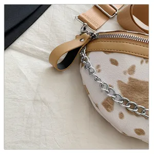 Detailansicht der modischen Damen Kuhmuster Umhängetasche Gürteltasche mit Kette.
