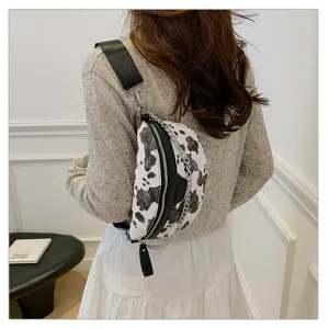 Detailansicht der modischen Damen Brusttasche mit Kuhmuster, Kettengurt und Lederbesatz.