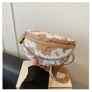 Detailansicht der stilvollen Kuhmuster Brusttasche mit schicker Metallkettenriemen.