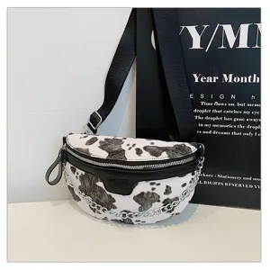 Nahaufnahme Detail der modischen Kuhprint Brusttasche mit schwarzem Leder und Kette.