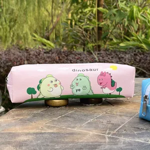 Detail view of the cute pink dinosaur pencil case, showing printed cartoon patterns and smooth zipper.