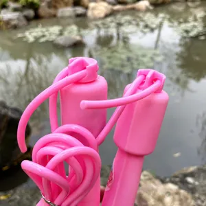 Detailed view of pink adjustable skipping rope handle and durable fitness cord for workout.