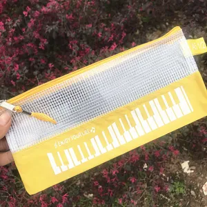 Primer plano de un estuche de malla amarilla con diseño de teclas de piano y cremallera.