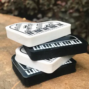 Primo piano dettagliato di gomme creative a forma di pianoforte con tastiera e note musicali.