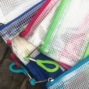 Detalle de estuche de malla de colores, organizador de papelería transparente con tirador.