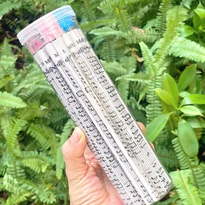 Gros plan de crayons à motifs de partitions musicales dans un tube en plastique transparent.
