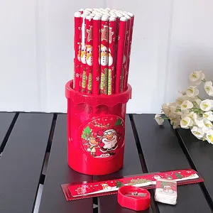 Detalle de papelería navideña con portalápices rojo, lápices HB y bonita regla festiva.