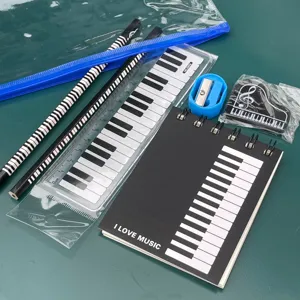 Detail de set de papeterie motif musique avec cahier touches de piano regle crayons gomme.
