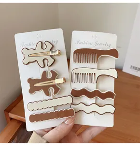 Vue détaillée d'un joli ensemble de pinces à cheveux café au lait avec ours et vagues.