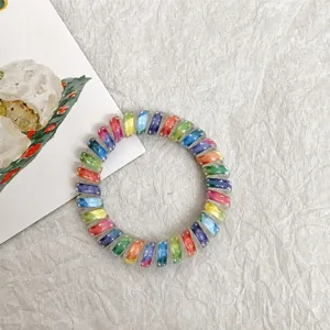 Detailed view of the colorful gradient telephone wire hair tie with cute star details, elastic.