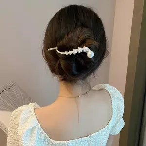 Détail de pince à cheveux queue de poisson en perles, accessoire élégant pour chignon.