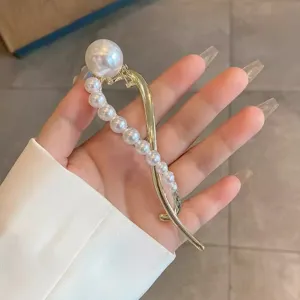 Jolie pince à cheveux dorée avec perles pour femme, design poisson idéal pour coiffure élégante.