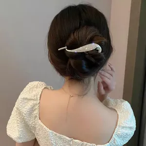 Vue détaillée d'une pince à cheveux argentée en strass en queue de poisson pour chignons.