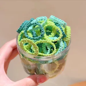Set di elastici per capelli colorati da bambini in barattolo trasparente, stile quotidiano.
