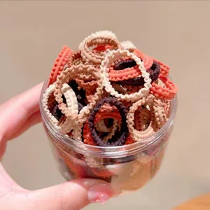 Vista ravvicinata dettagliata di elastici per capelli colorati per bambini in barattolo.