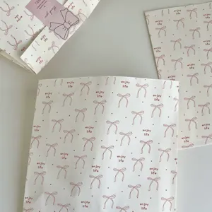 Bow print paper gift bags detail view, perfect for birthday party packaging and holiday presents.