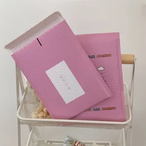Detalle de sobre acolchado rosa con oso de dibujos animados, diseño antichoc grueso para regalos.