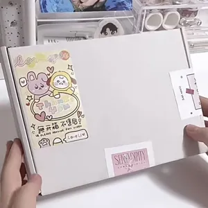 White cardboard mailing box with cute cartoon character stickers for packing and storage.