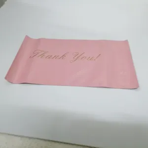 Detailed close-up view of the thick pink plastic mailing bag with elegant thank you text print.