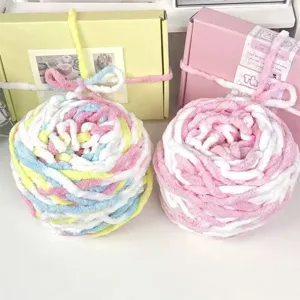 Primer plano de hilo esponjoso macaron y cajas de regalo decorativas, ideal para manualidades.