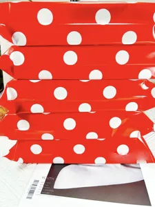 Detailed shot of red and white polka dot waterproof express packaging mailer bags stacked.