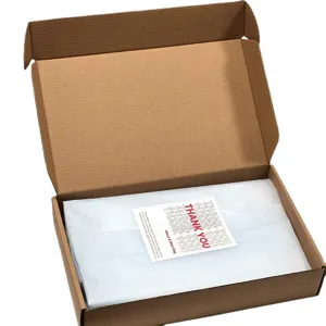 Kraft corrugated mailer box detail view with white tissue paper and thank you sticker packaging.