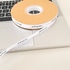 Weißes bedrucktes Schleifenband mit englischen Buchstaben zum Geschenkverpacken.