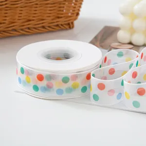 Detailed view of white sheer ribbon featuring colorful polka dots, perfect for gift wrapping.