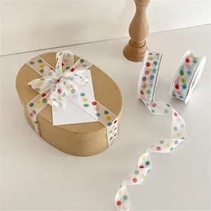 Transparente, transparente Schleife mit bunten Punkten zum Geschenkverpacken und Dekorieren.