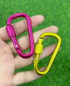 Dettaglio di moschettone in alluminio con blocco a vite per zaini da campeggio outdoor.