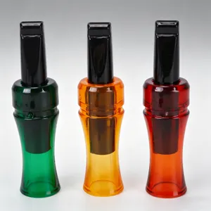 Close-up detail of multi-color plastic outdoor game calls and whistles in green, orange and red.