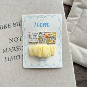 Cute sweet floral fabric and yellow mesh hair clip detail close up, children hair accessory