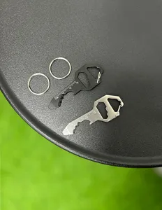Detailed shot of EDC multi-tool key shaped bottle opener with scale and keyring setup.